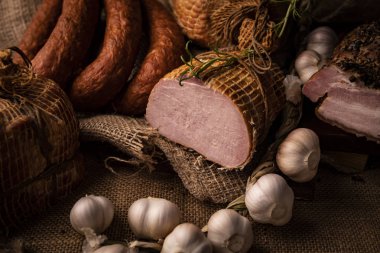 Füme domuz jambon, domuz pastırması ve sosis. Soğuk etlerin ev yapımı bir bileşimi.