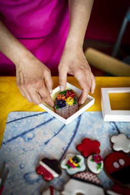 Krema ile süslenmiş zencefilli çörekler. Iştah açıcı renkli kurabiyeler.