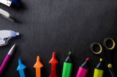 Kağıt aksesuarlar, renkli ofis ekipmanları. Koyu bir arka plan üzerine kompozisyon.