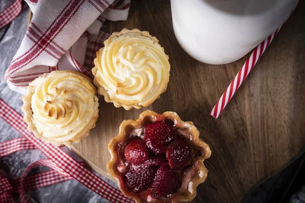 Mini taartjes met aardbeien en muffins met pudding. — Stockfoto