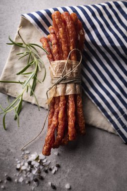 İnce sığır sosisi. Taş arka planda otlar ile ince sosis