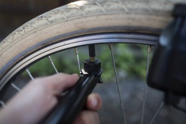 Bir el pompası kullanarak bisiklet tekerleği pompalama.