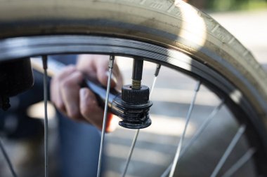 Bir el pompası kullanarak bisiklet tekerleği pompalama.