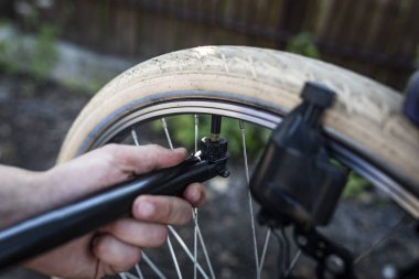 Bir el pompası kullanarak bisiklet tekerleği pompalama.