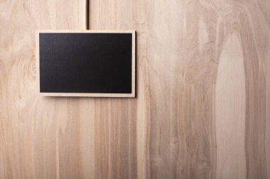 Ahşap bir arka planda tebeşir ile yazılmış metin için alan ile siyah plaka