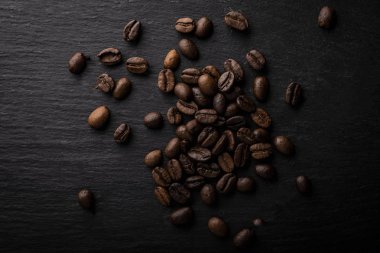 Kahve çekirdekleri. Koyu bir masada kavrulmuş kahve kızartması.