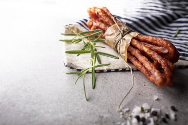 İnce sığır sosisi. Taş arka planda otlar ile ince sosis