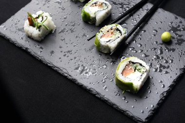 Suşi. Somon, salatalık, peynir, kampyo ve avokado dilimleri ile suşi rulo.