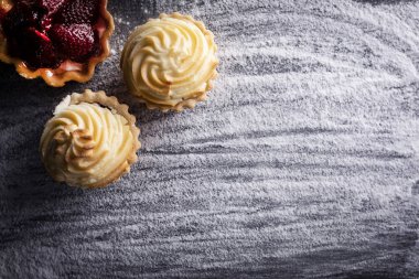 Dolgulu kekler, un arka planında kremalı kekler.