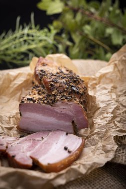 Pastırma otlar serpilir, aromatik duman ile füme.