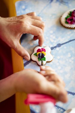 Kurabiyeler krema ile süslenmiş. Iştah açıcı renkli kurabiyeler.