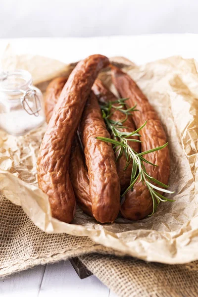 Dünne Wurst in Komposition mit Kräutern, geräucherte Wurst. — Stockfoto