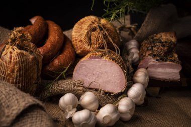 Füme domuz jambon, domuz pastırması ve sosis. Soğuk etlerin ev yapımı bir bileşimi.