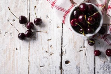 Ahşap beyaz bir arka plan üzerinde kiraz. Sulu kiraz.