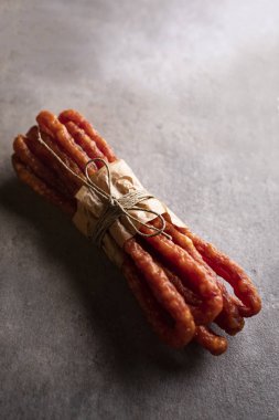 Etli atıştırmalık. Koyu bir arka plan üzerinde ince sosis. 