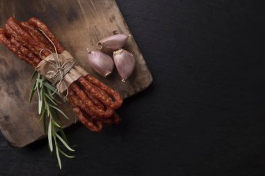 Kırsal et. Koyu bir arka plan üzerinde sarımsak ile ince sosis