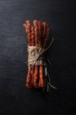 Koyu bir arka plan üzerinde otlar ile ince sosis