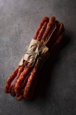 Etli atıştırmalık. Koyu bir arka plan üzerinde ince sosis. 