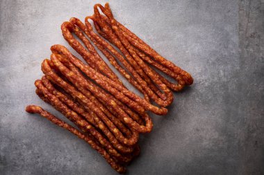 Sosis. Koyu bir arka plan üzerinde ince sosisler. Etli atıştırmalık.