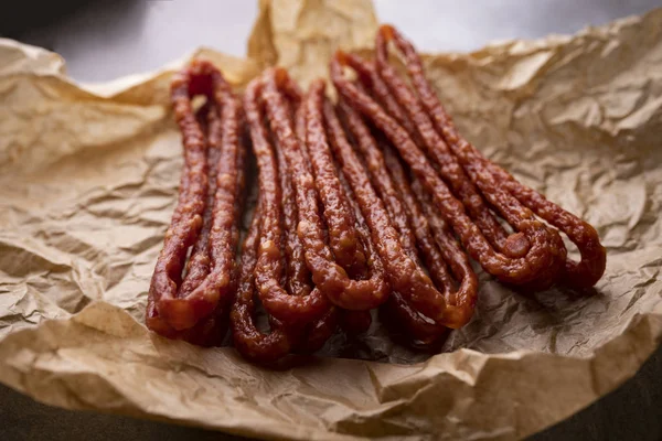 Meat tasty snack. Thin dried pork sausages. — Stock Photo, Image