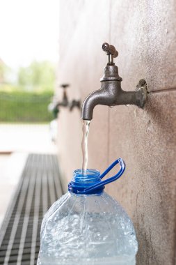 Kaynak suyu. Plastik bir şişeye su dökmek.