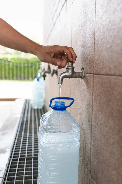 Agua de manantial. Verter agua en una botella de plástico . — Foto de Stock