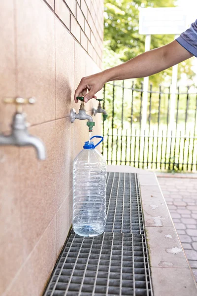 Ingesta de agua de ligoceno. Agua potable limpia. Verter agua en una botella de plástico . — Foto de Stock