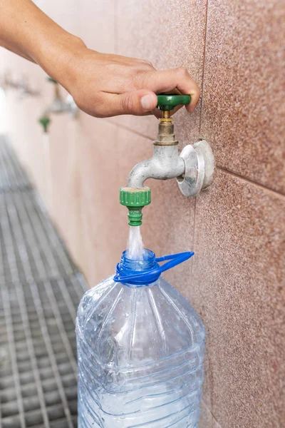 Muy profundo. Verter agua en una botella de plástico . — Foto de Stock