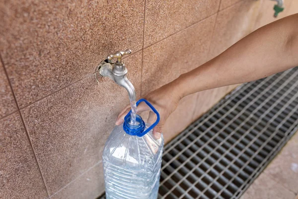 Muy profundo. Verter agua en una botella de plástico . — Foto de Stock