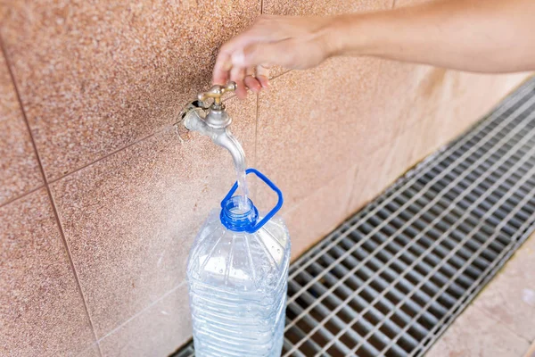 Agua de manantial. Verter agua en una botella de plástico . — Foto de Stock