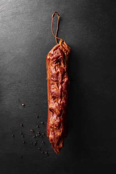 Bacon de porc fumé sur fond noir. Saucisse de pays — Photo