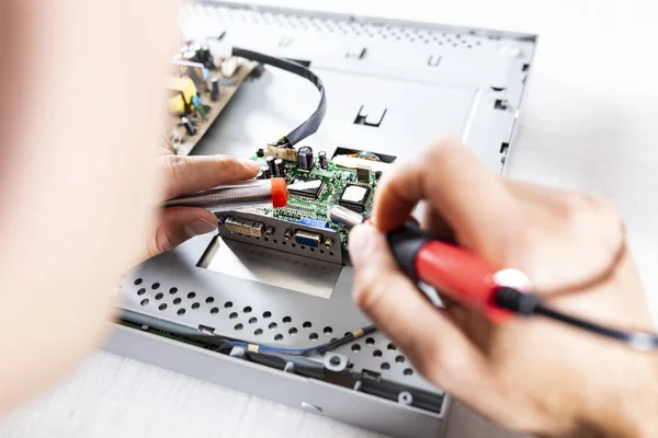 Computer repair. A service technician solders components