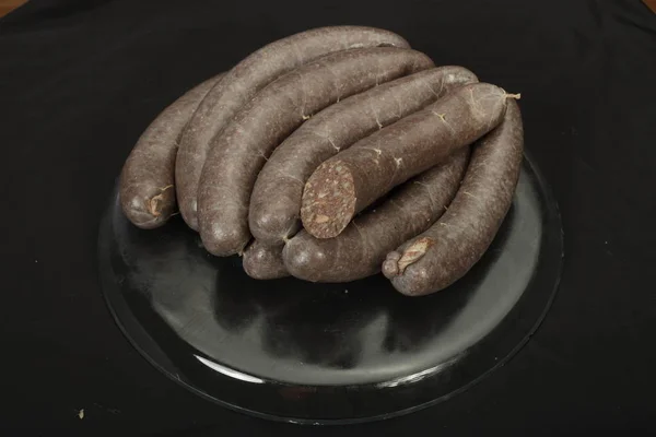 Black pudding. Traditional home-made sausage made from groats and blood on a dark plate — Stock Photo, Image