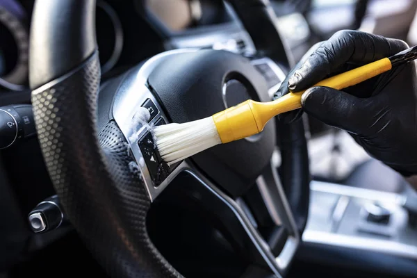 Detalhes do carro. Vácuo e limpeza de recantos no painel e no volante do carro — Fotografia de Stock