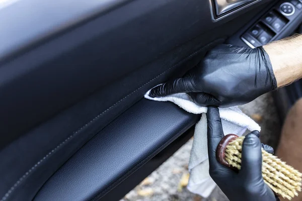 A limpar o interior do carro. Estofos de couro encerado na porta do carro — Fotografia de Stock