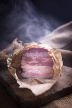 Kağıda sarılmış tütsülenmiş pastırma şeritleri. Lezzetli ev yapımı sandviçler..