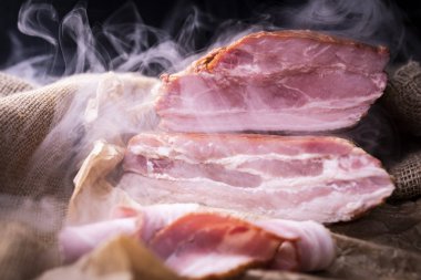 Kırsal bir kompozisyonda tütsülenmiş domuz pastırması. Geleneksel, tütsülenmiş, domuz pirzolası. 