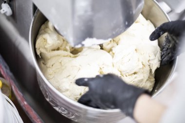 Yiyecek üretimi. Makine hamur yoğuruyor. Aşçı yemek için malzemeleri hazırlar..