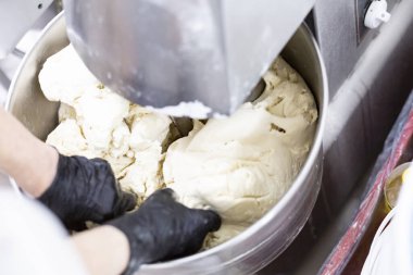 Makine hamur yoğuruyor. Aşçı yemek için malzemeleri hazırlar..