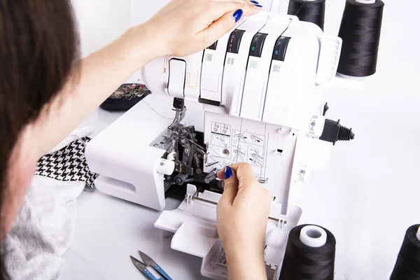 Overlock. The woman sews the knit fabric on the overlock — Stock Photo, Image