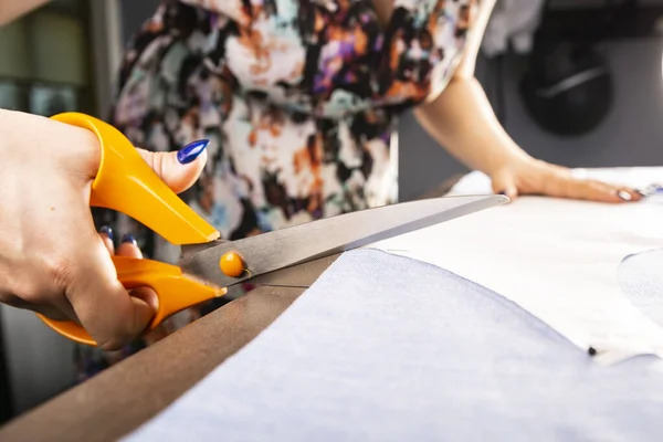 Tailoring. The seamstress cuts the material with sewing scissors — Stock Photo, Image