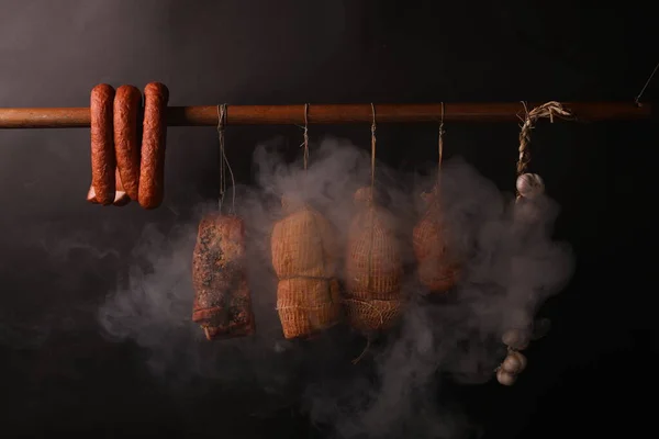 Un affumicatoio tradizionale. Salsicce, prosciutti e pancetta circondati dal fumo in un affumicatoio . — Foto Stock