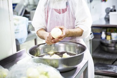 Gıda üretimi, yemek hazırlama aşamaları. Aşçı soğanı keser.