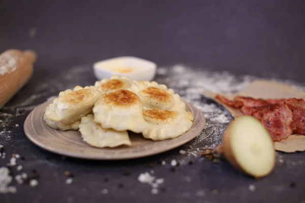 Traditionele Russische knoedels gevuld met kaas, aardappelen en spek gebakken in een pan — Stockfoto