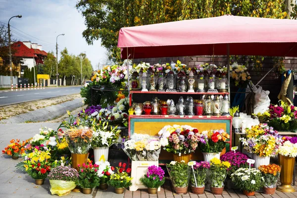 Продам могильные свечи и цветы рядом с кладбищем. Полки полные различных фонарей могилы. День всех святых . — стоковое фото