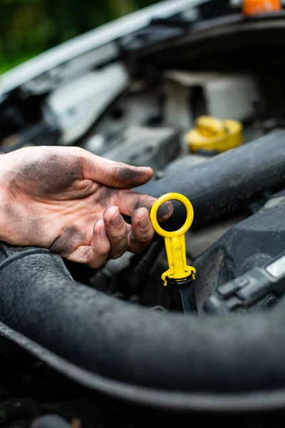 Kontrola vozidla. Mechanik kontrolující hladinu motorového oleje pod kapotou auta. — Stock fotografie