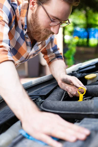 Vérification du niveau d'huile moteur de la voiture. Homme regardant sous le capot de sa voiture. — Photo