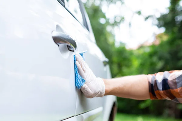 Detalle automático. Mano masculina en guante protector puliendo una pintura automotriz con cera. Limpieza exterior del coche . — Foto de Stock