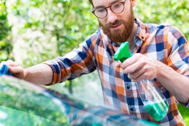 Otomatik temizleme. Adam araba kozmetikleriyle araba temizliyor.. 