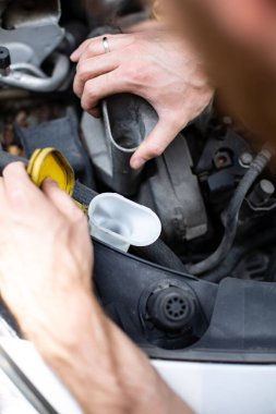 Arabada sıvı seviyelerini kontrol edip dolduruyorum. Araç kontrolü için. Arabanın kaputunun altında..